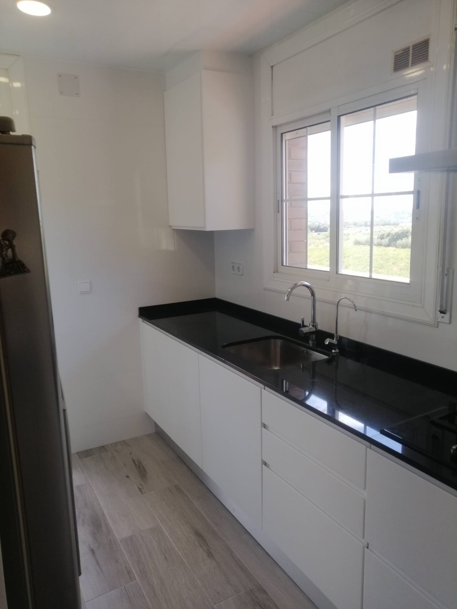 Reforma de cocina con mobiliario blanco y encimera de calidad