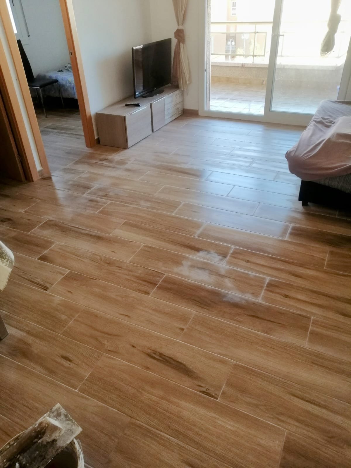 Pavimento efecto madera instalado en reforma integral en Cunit